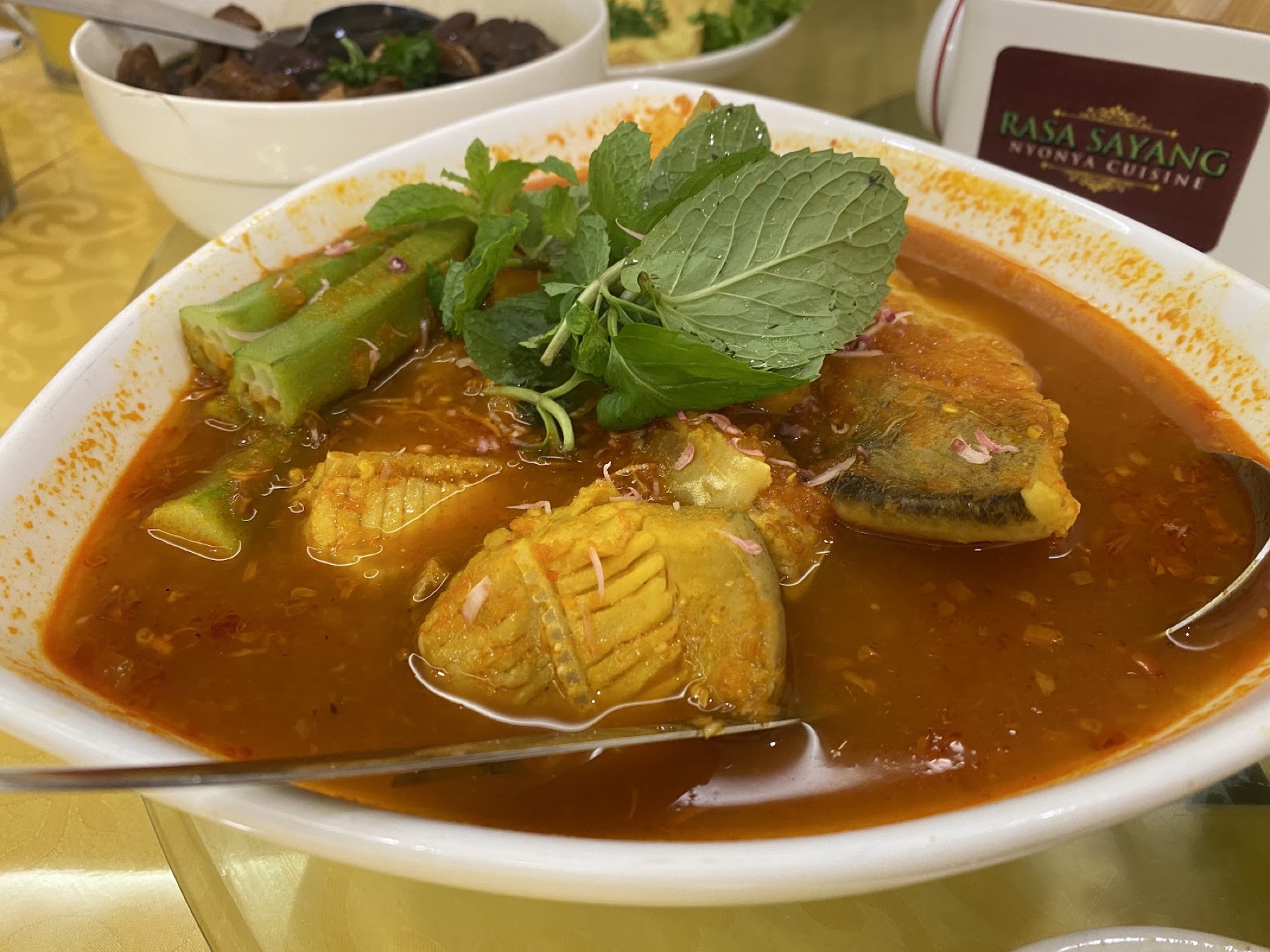 Assam pedas fish in a tangy tamarind-chilli broth with okra and torch-ginger garnish