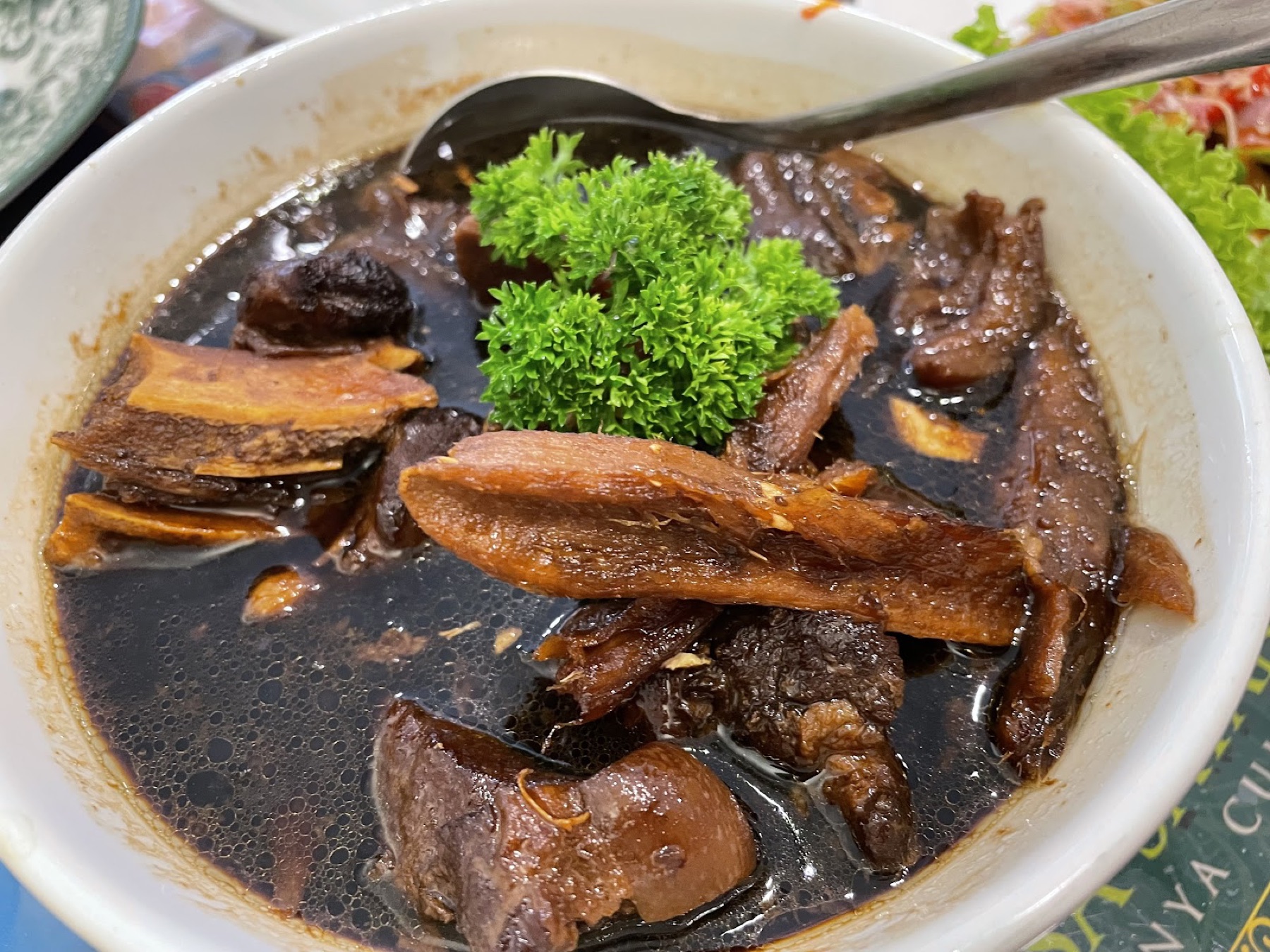 Nyonya kari bak kut — dark, aromatic herbal pork in a deep braising broth